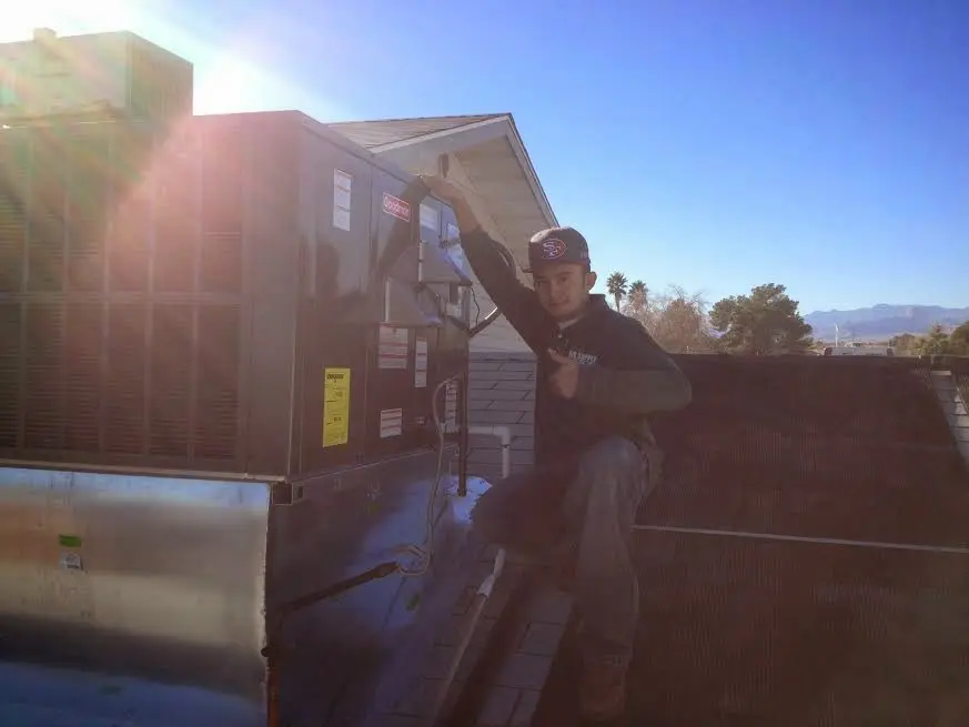 HVAC technician performing HVAC Inspection on a rooftop unit in Hopkins